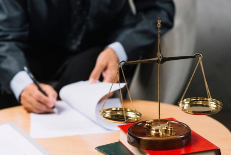 Man preparing documents near Scales of Justice