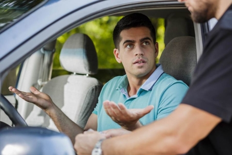 Man in a car talking to a police officer