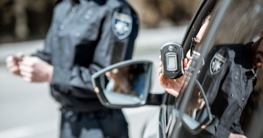 policeman checking woman driver for alcohol intoxication
