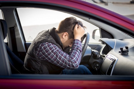Man distressed behind the wheel of a car